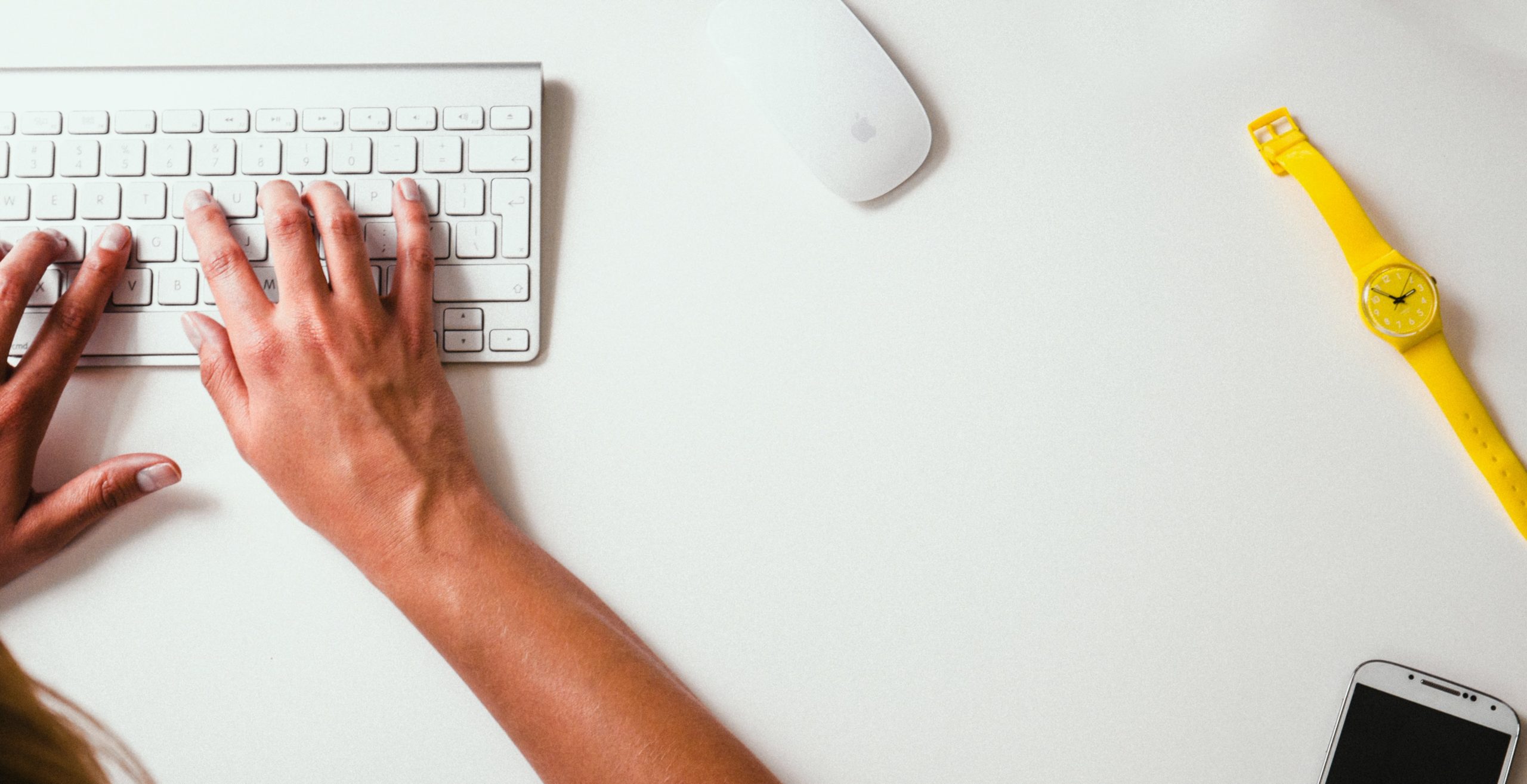 someone typing on a keyboard white table