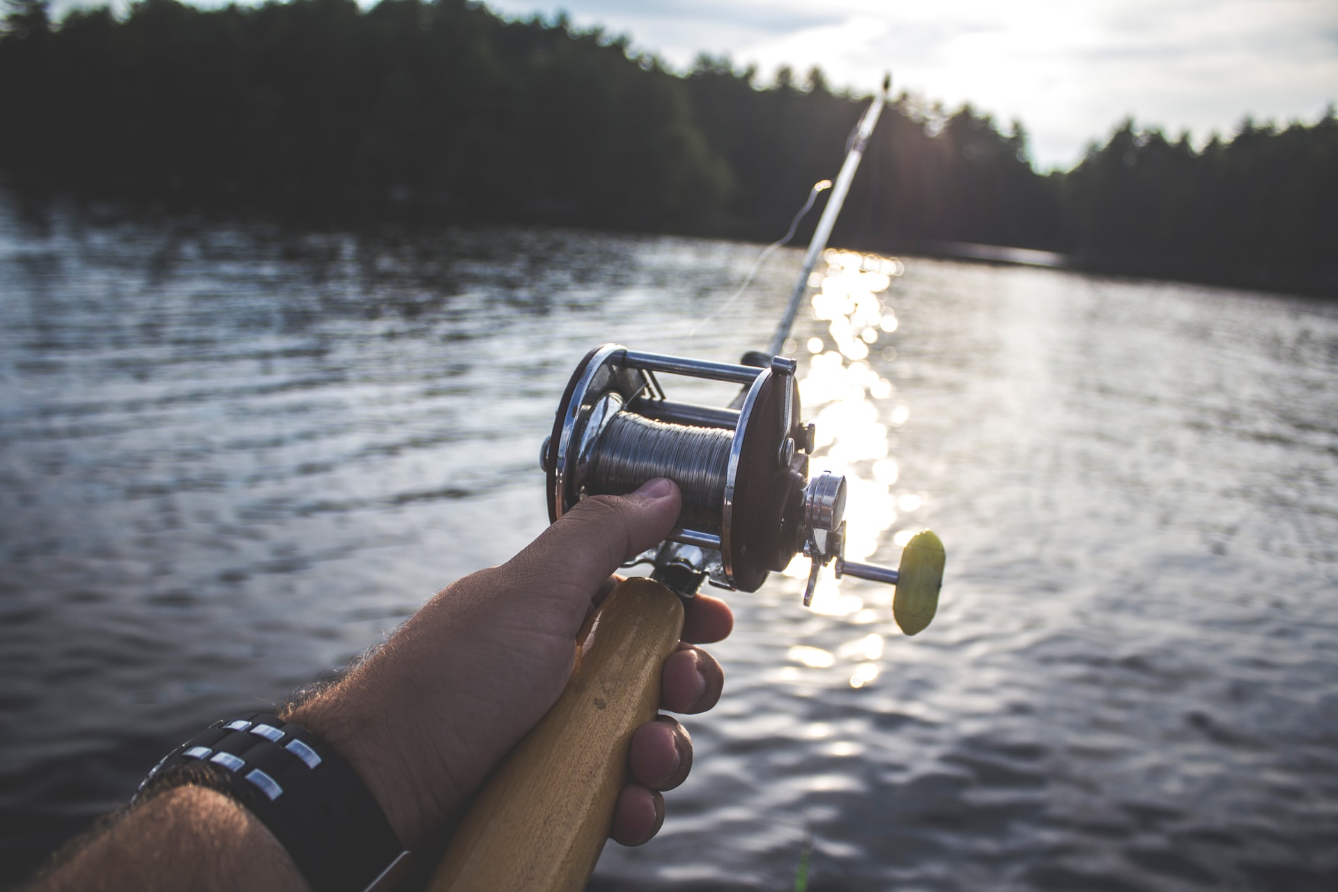 person with fishing rod on lake