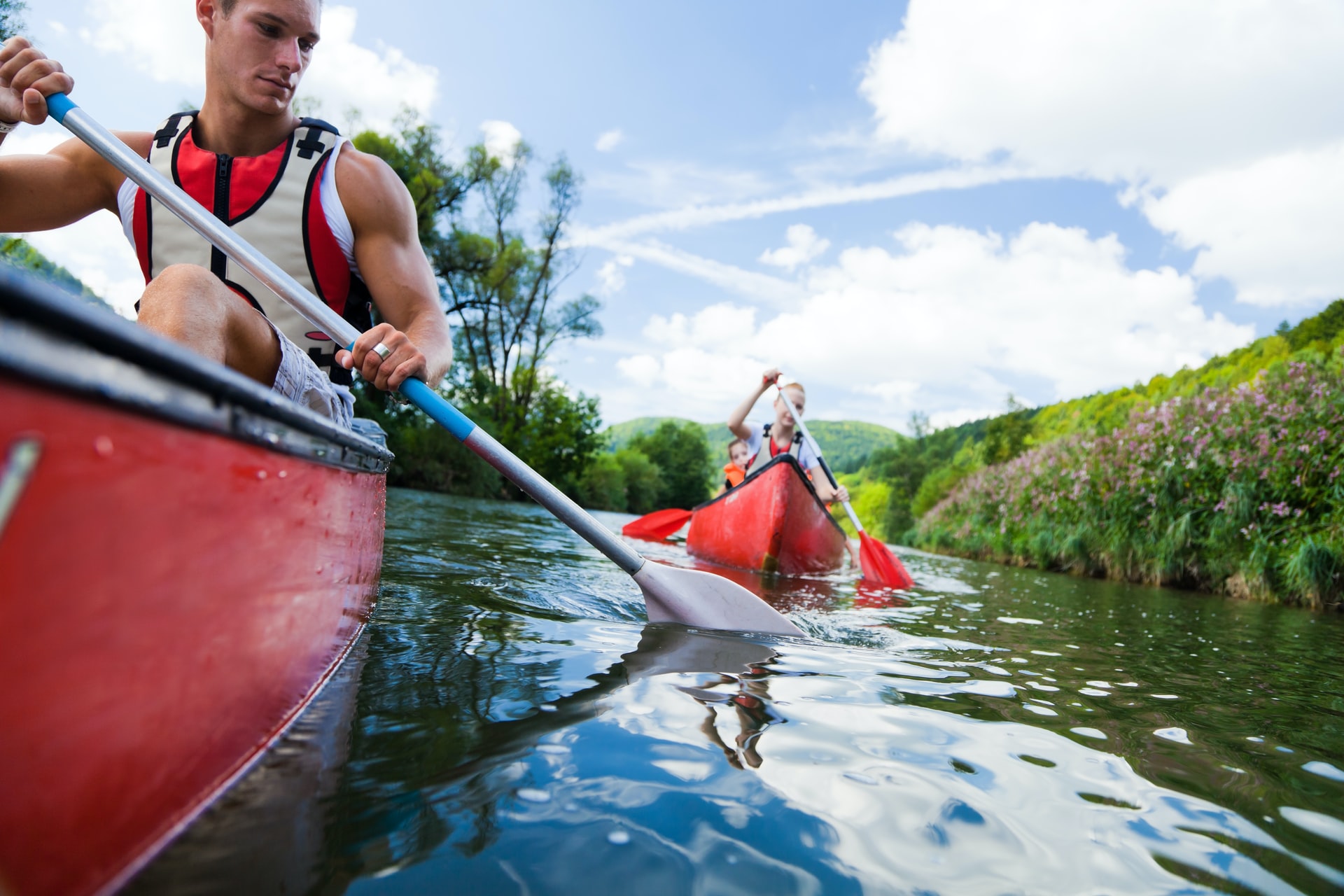 people in red kayaks on a river