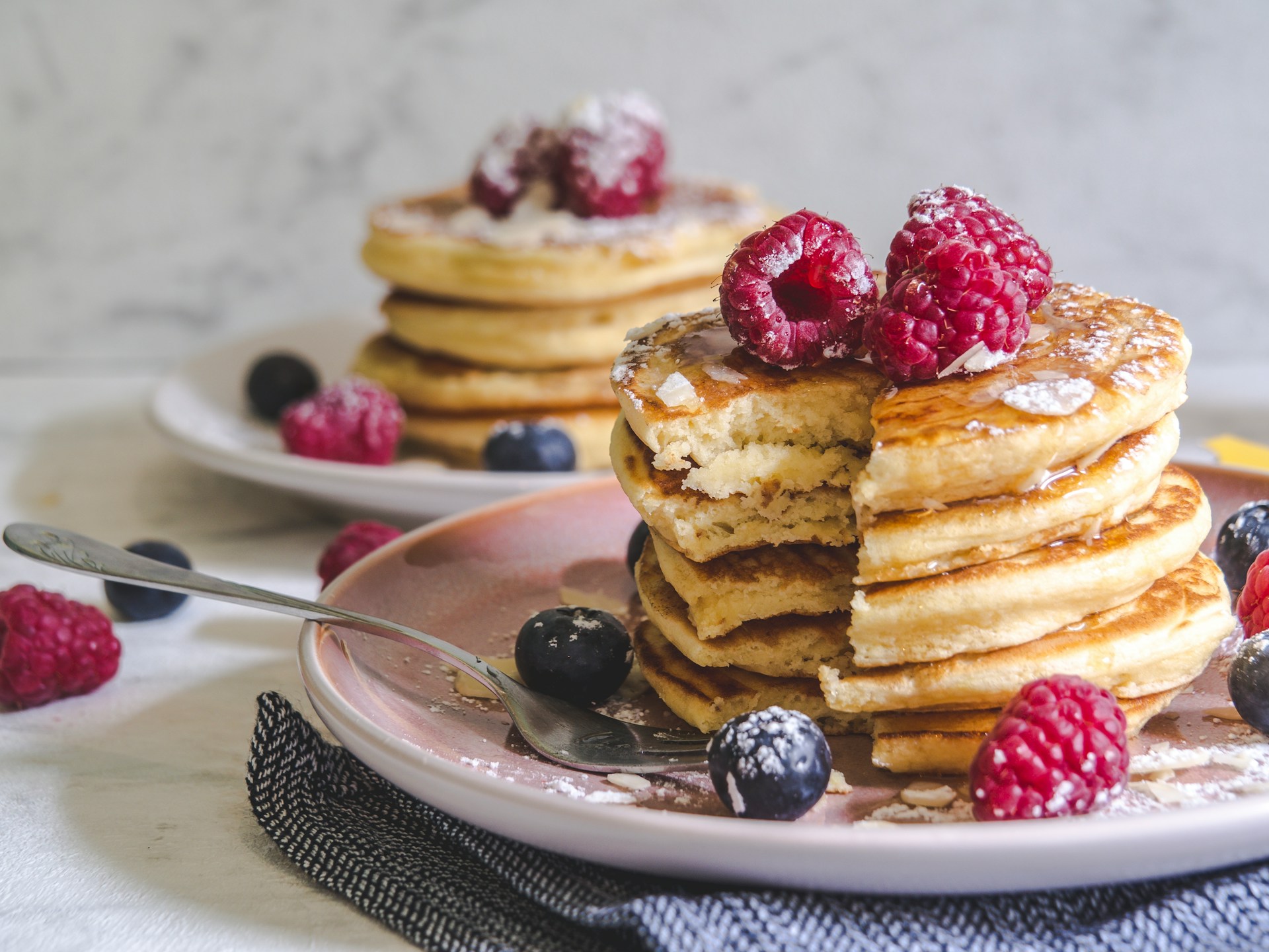 Two stacks of pancakes with berries